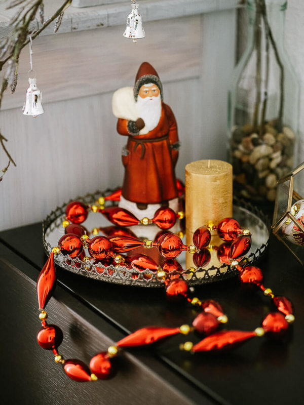 Christbaumkette in rot auf einem Tablett mit einem Weihnachtsmann