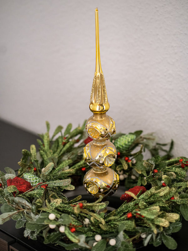 Christbaumspitze in gold mit 3 Reflexen in einem Adventskranz