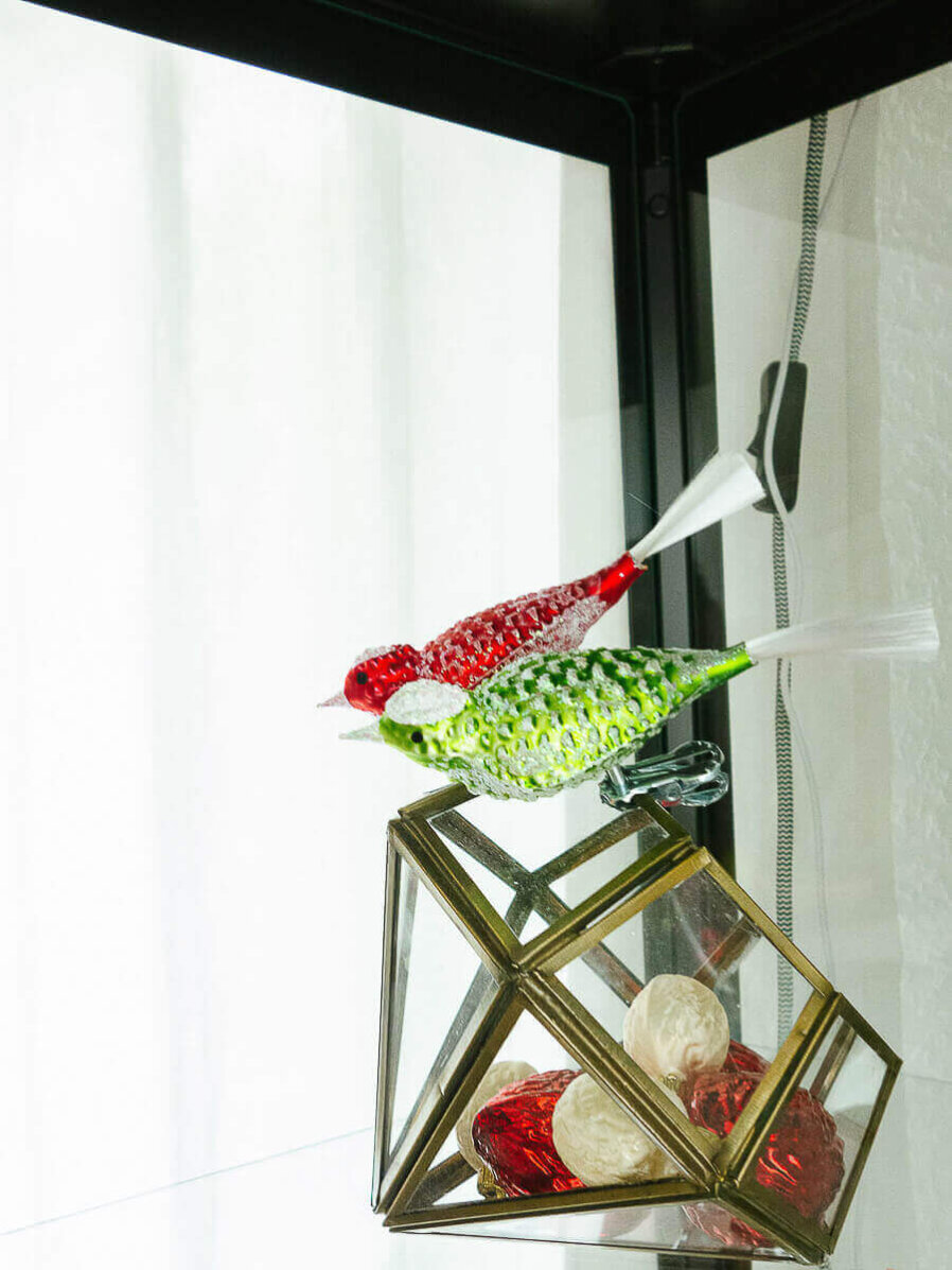 Vogel in hellgrün und rot auf einer Glasschale